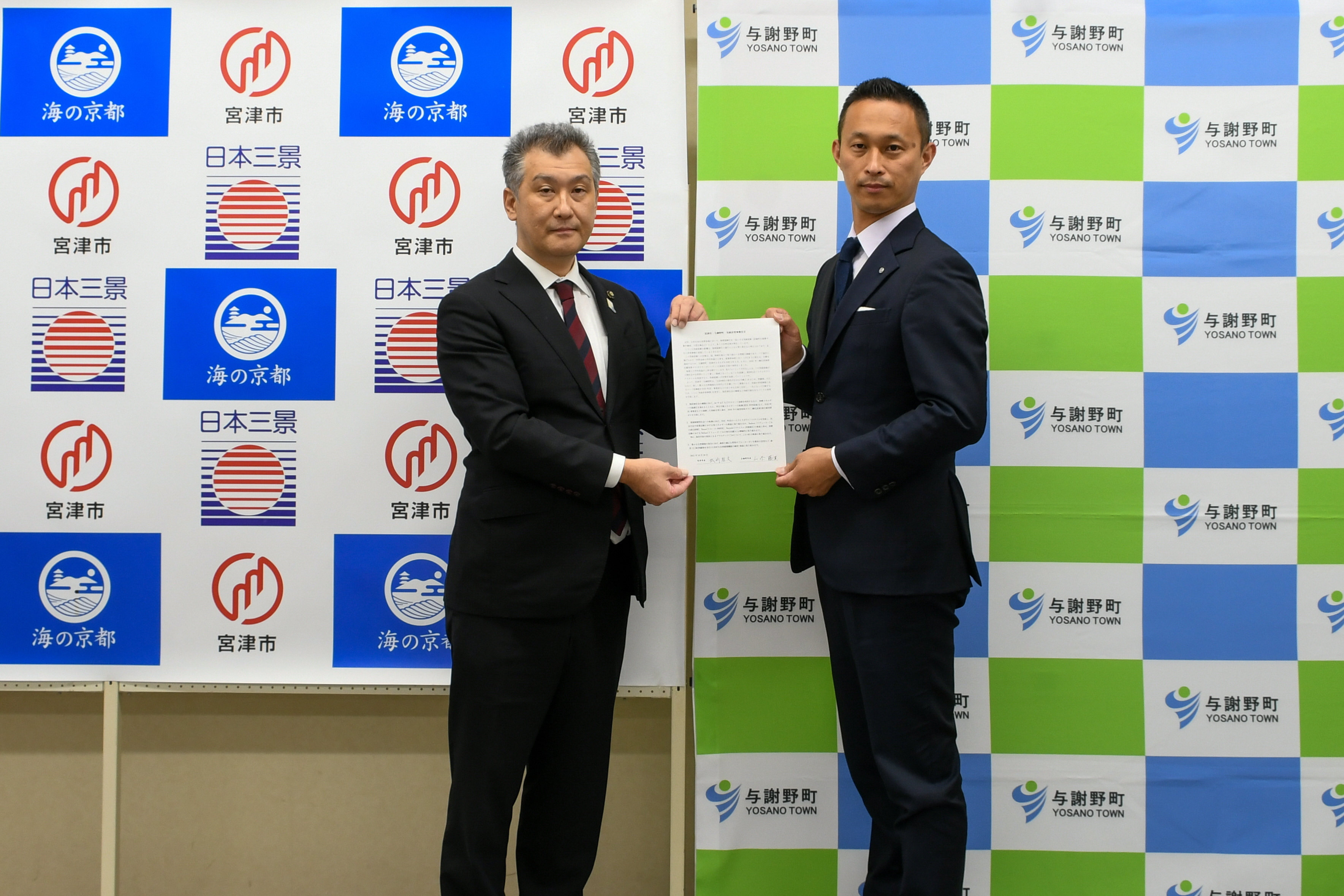 宣言書を掲げる城﨑宮津市長(左)と山添町長(右)